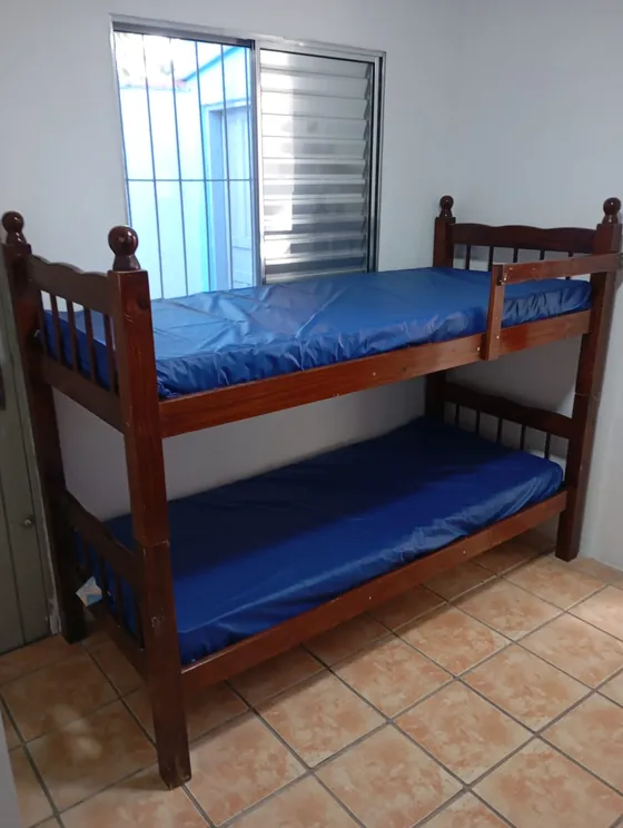 Quarto com beliche junto da janela.