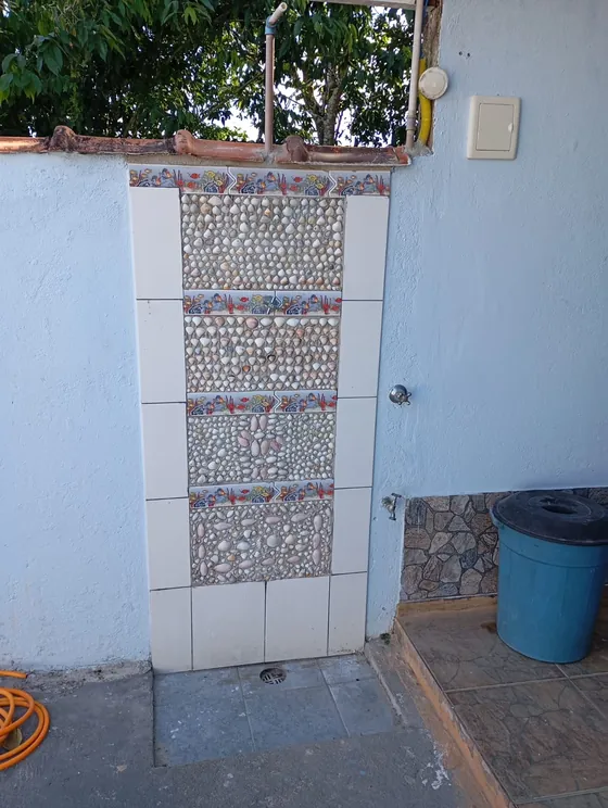Ducha externa com parede de pastilhas.