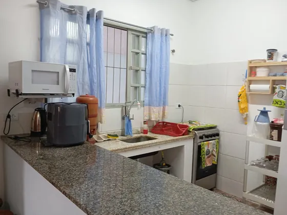 Cozinha com cortinas azuis, pia e fogão.