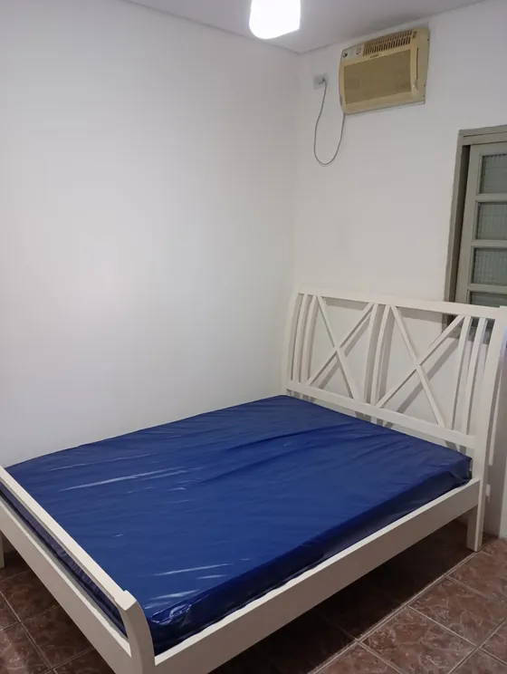 Quarto com cama de casal e ar-condicionado.