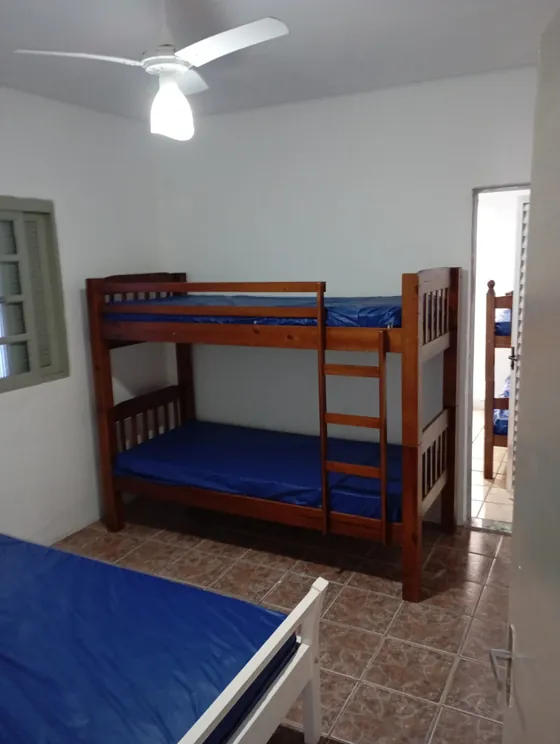 Quarto com beliche e ventilador de teto.