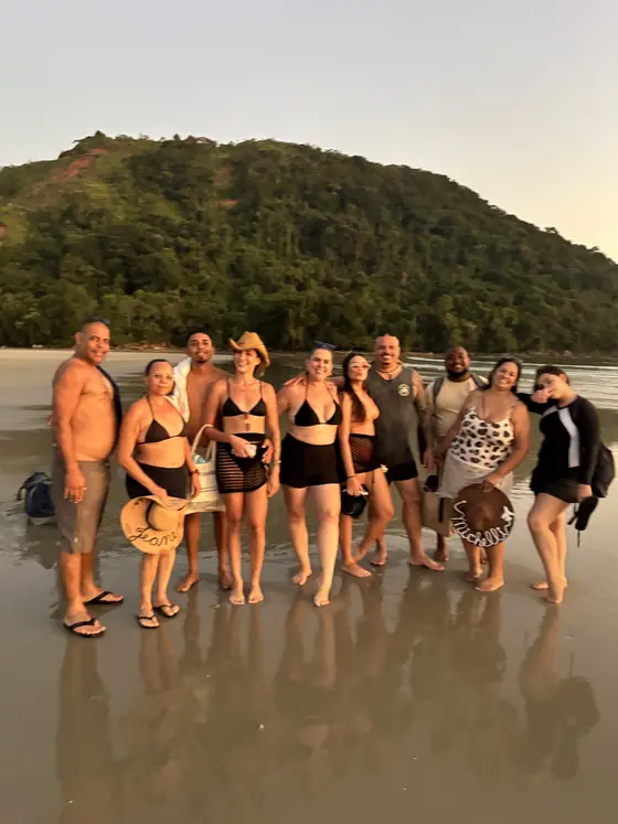 Grupo do passeio posando na areia da Ilha dos Gatos no fim da tarde.