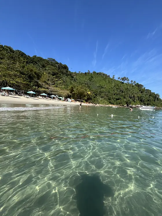A praia d’As Ilhas vista do mar, com guarda-sóis na faixa de areia.