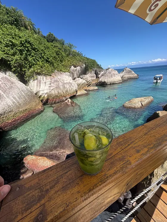 Caipirinha na mureta de madeira do quiosque do Montão do Trigo, de frente para a enseada.