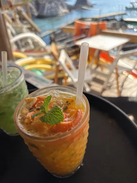 Drinks servidos em copos sobre uma bandeja, no quiosque da ilha.