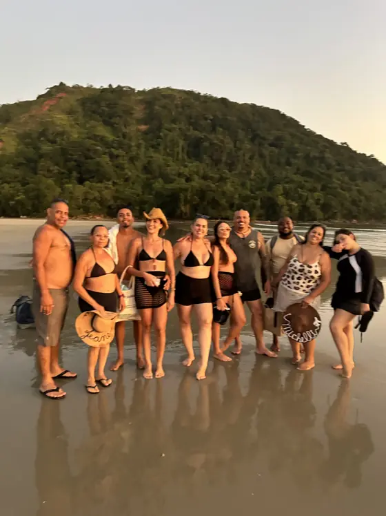 Grupo de passageiros reunido na areia no fim do passeio.