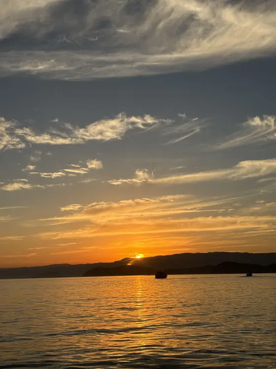 Céu alaranjado com nuvens finas sobre o mar, no início da manhã.